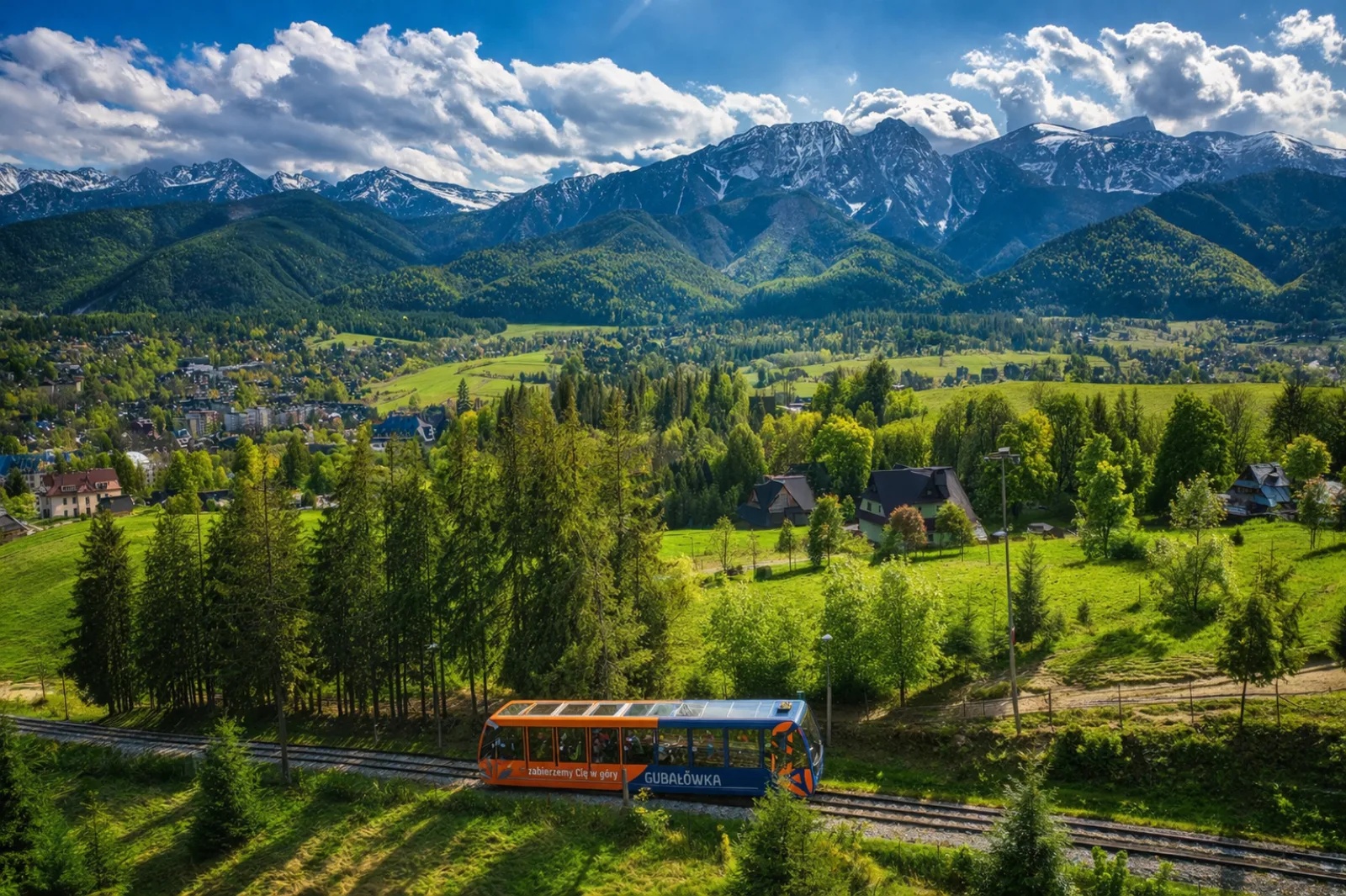 Gubałówka funicular car above Zakopane with green slopes and rocky peaks