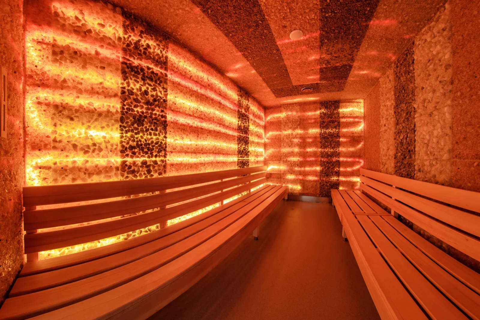 Sauna with glowing crystal-studded walls and long wooden benches