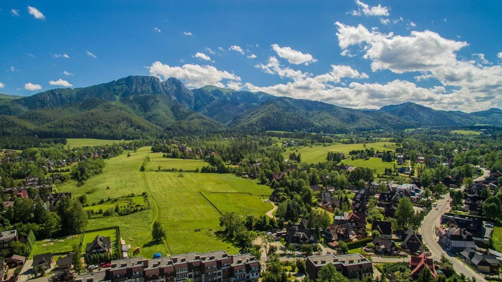 Aerial view of Zakopane's meadows and houses below the Tatra ridge