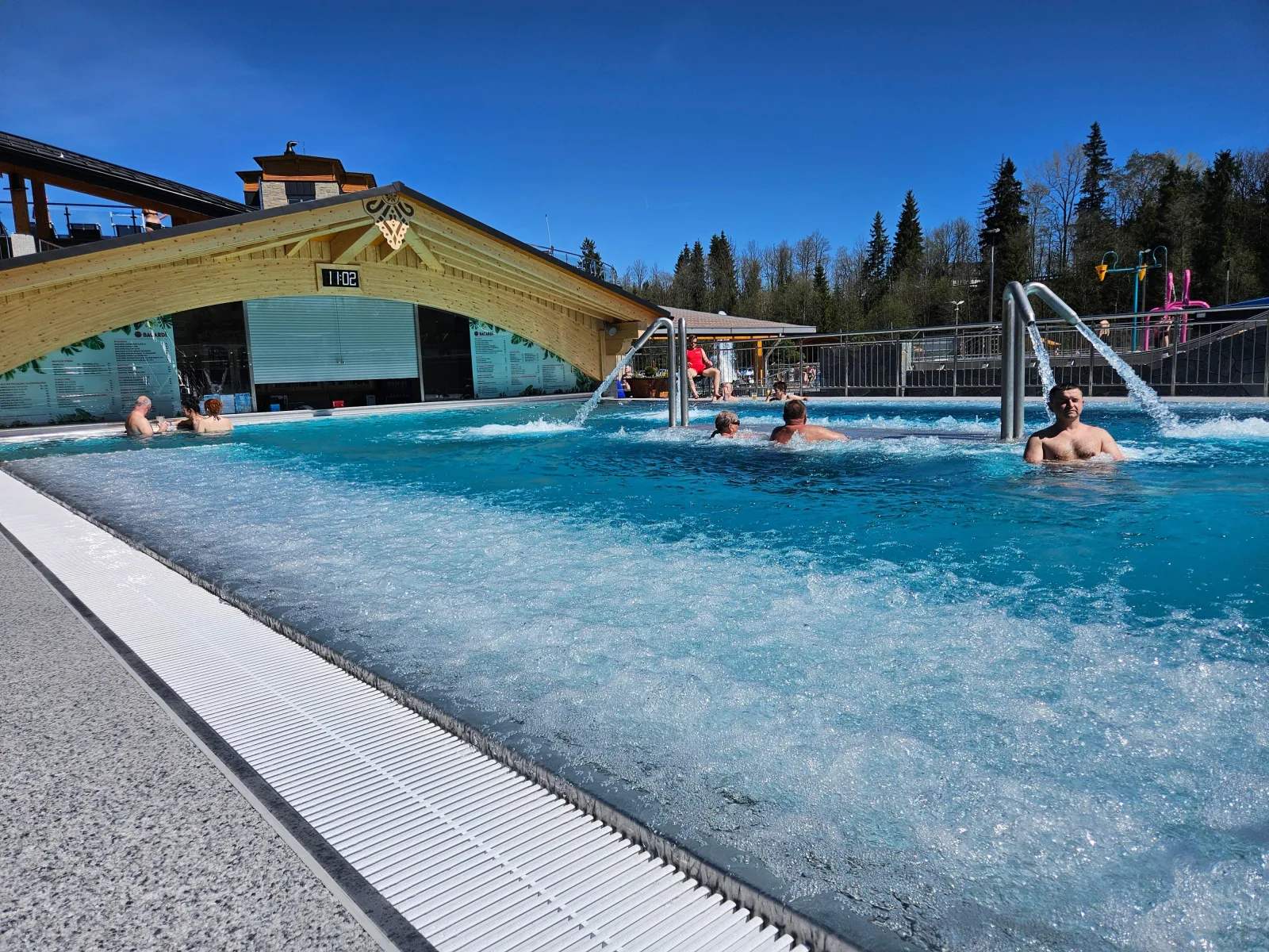 Bubbling outdoor whirlpool with water jets beside a wooden bar