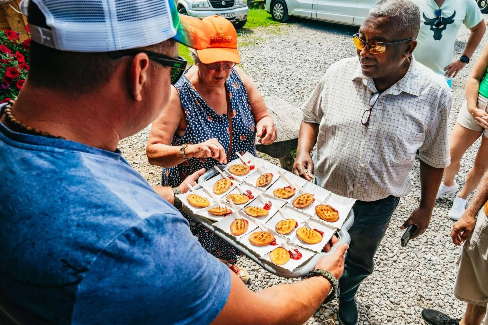 Guide holding a tray of grilled smoked cheese with cranberry for guests