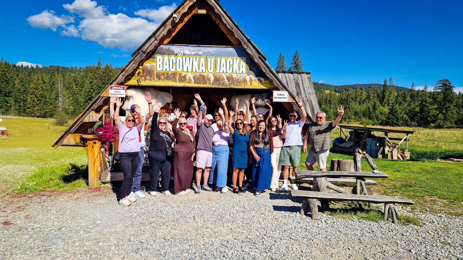 Tour group waving outside the Bacówka u Jacka shepherd's hut