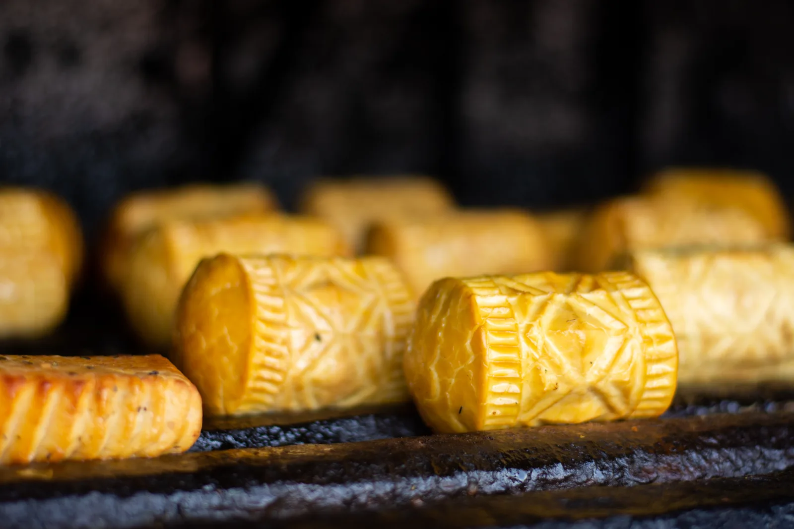 Spindle-shaped smoked cheeses with carved patterns in close-up