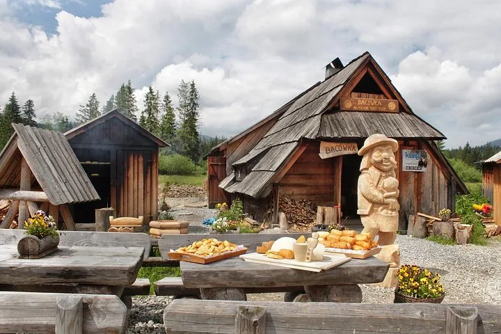 Shepherd's hut with smoked cheeses on a table and a carved figure