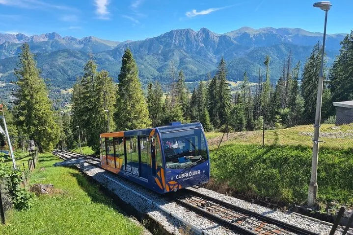 Gubałówka funicular car on its track with green Tatra peaks behind