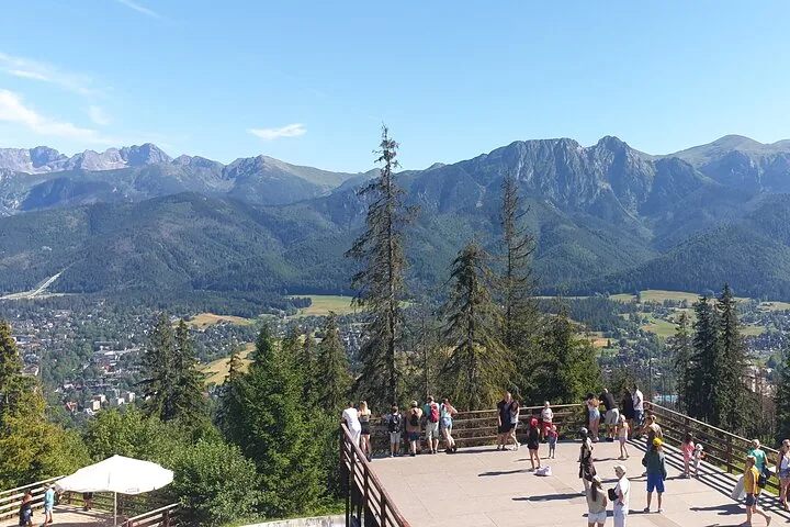 Visitors on a viewing terrace above Zakopane looking at the Tatras