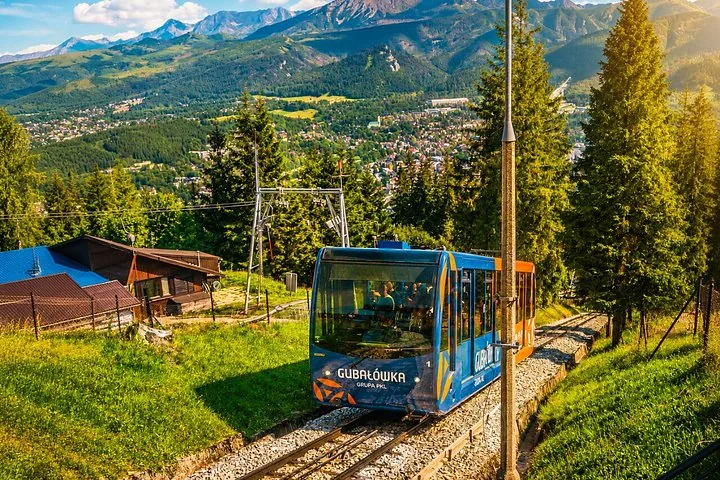 Gubałówka funicular car climbing above Zakopane with mountains behind