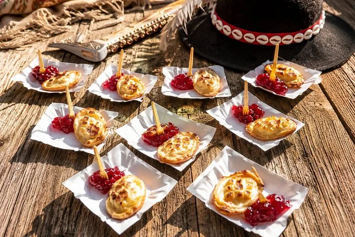 Grilled smoked cheese with cranberry sauce on paper trays outdoors