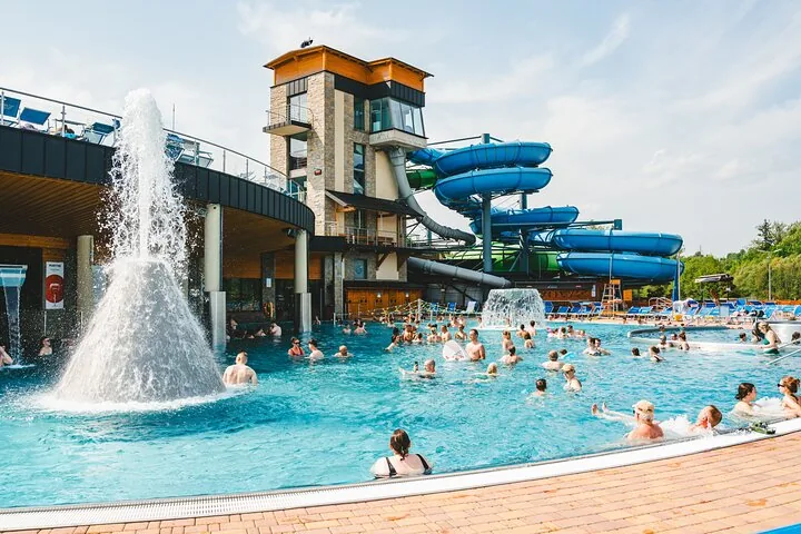 Outdoor thermal pool with a fountain and blue water slides