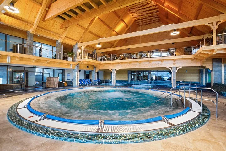 Large indoor whirlpool under a high timber roof with a gallery